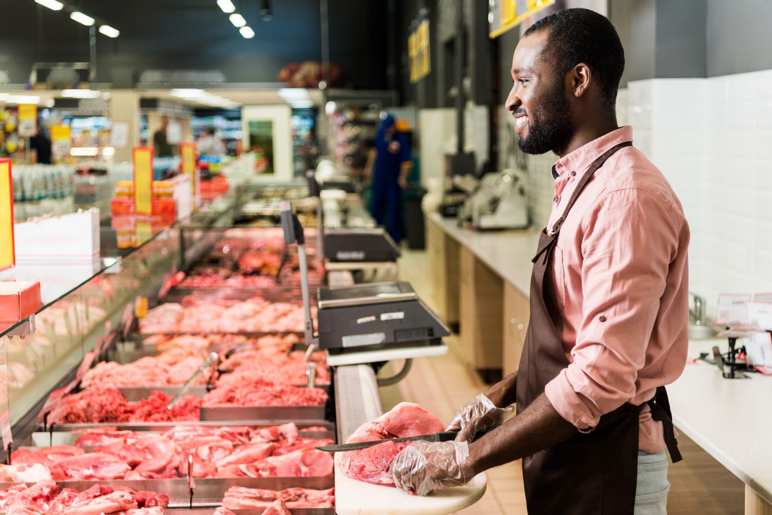 Happy butcher selling lamb chops, sheep meat production industry